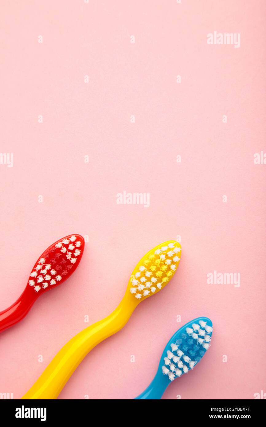 Colorful toothbrushes on a pink background. Top view Stock Photo - Alamy
