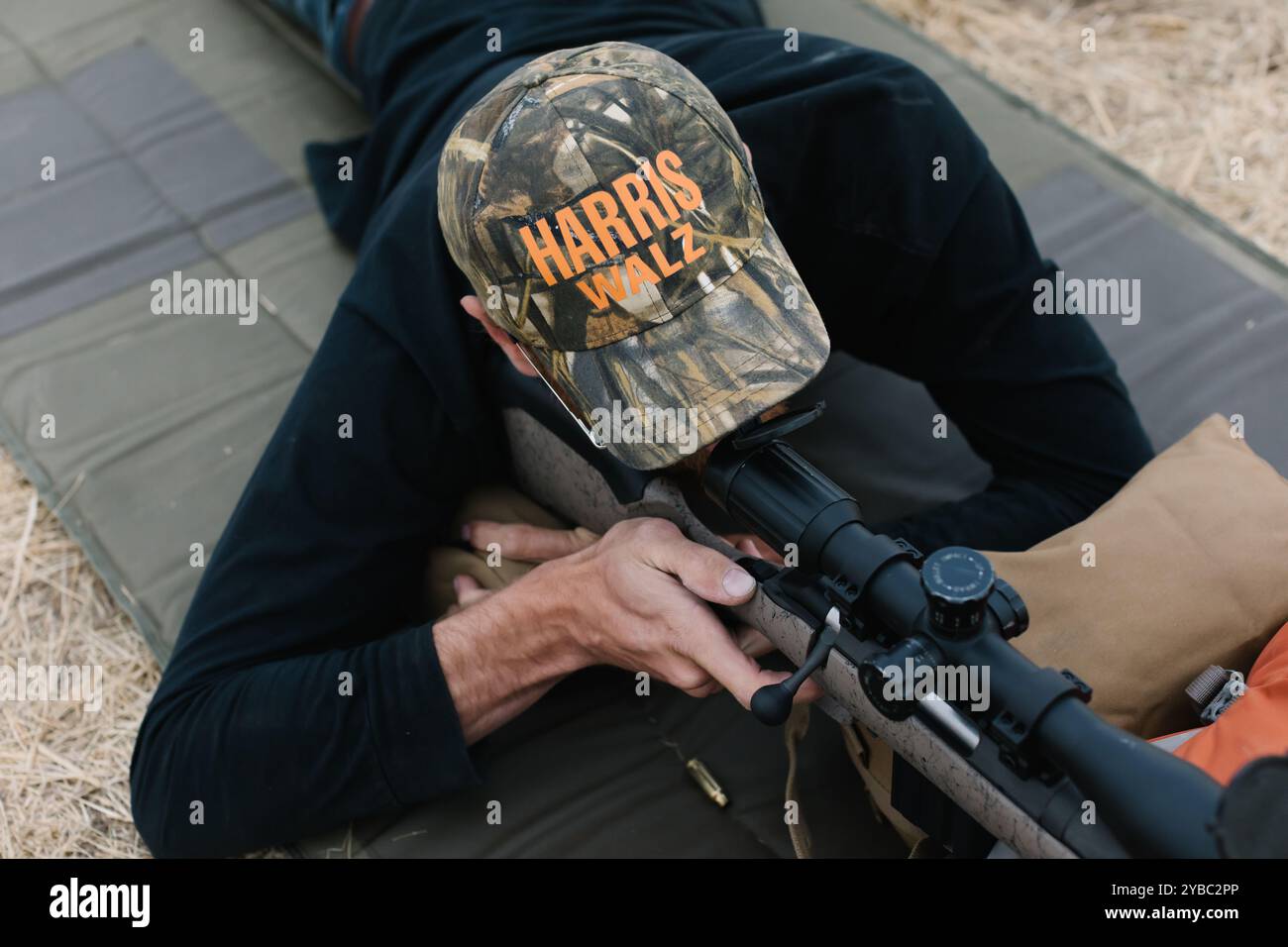 Man in Harris Waltz hat aiming rifle at Boise range Stock Photo