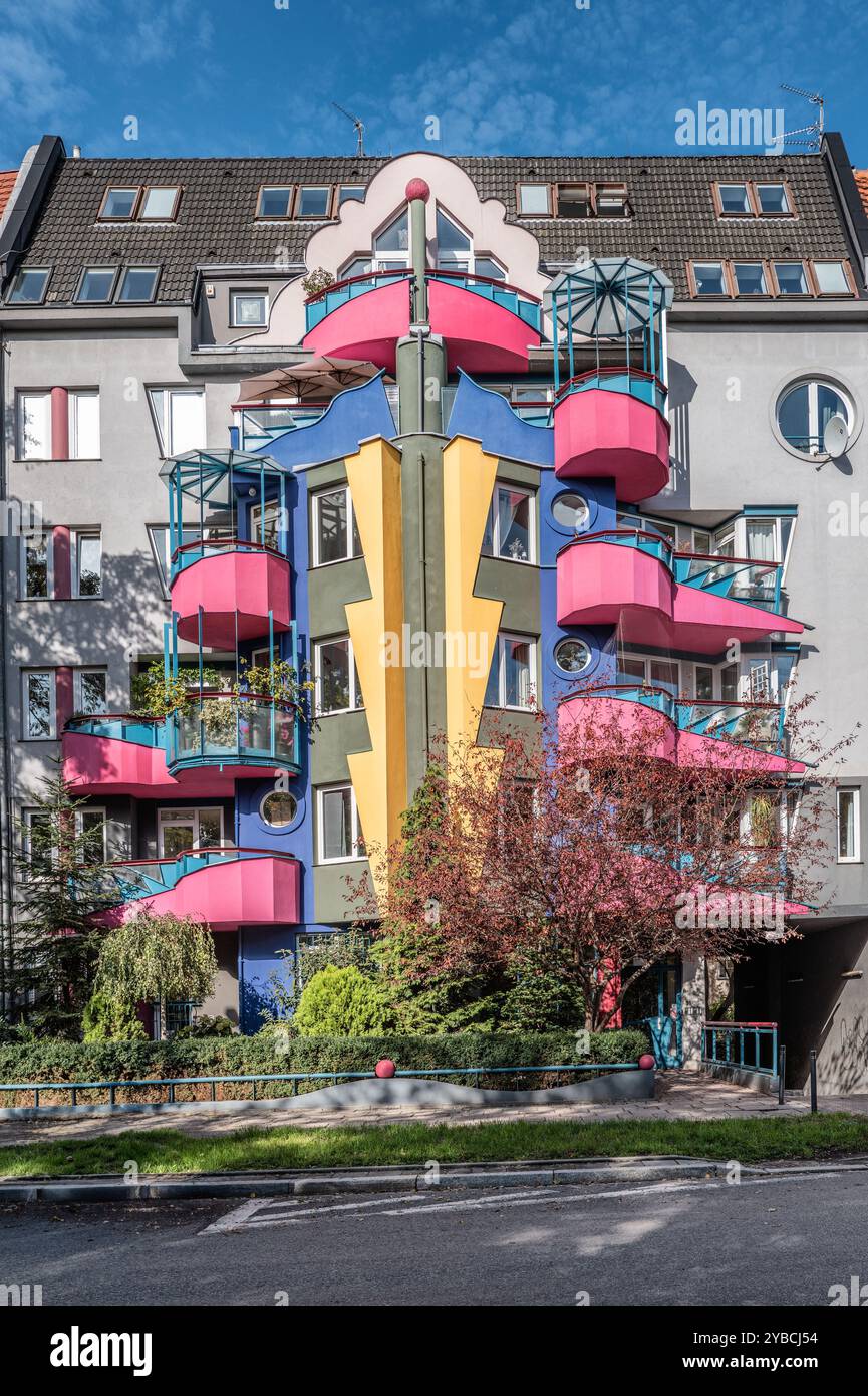 A modern apartment building showcasing vibrant colors and unique balcony designs. The facade features bold architecture and creativity, set against a Stock Photo