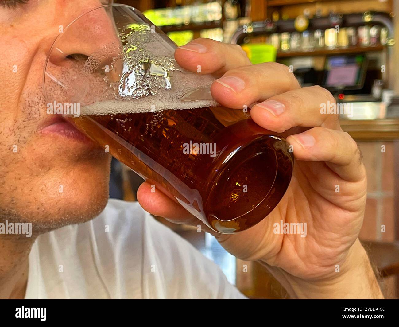 Man drinking a glass of beer. Close view. - Smartphone Captured Stock Image