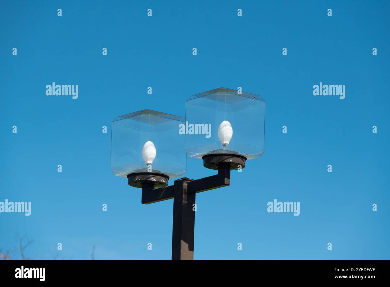 Street light lamp with a cube glass cover. Daytime and blue sky Stock Photo