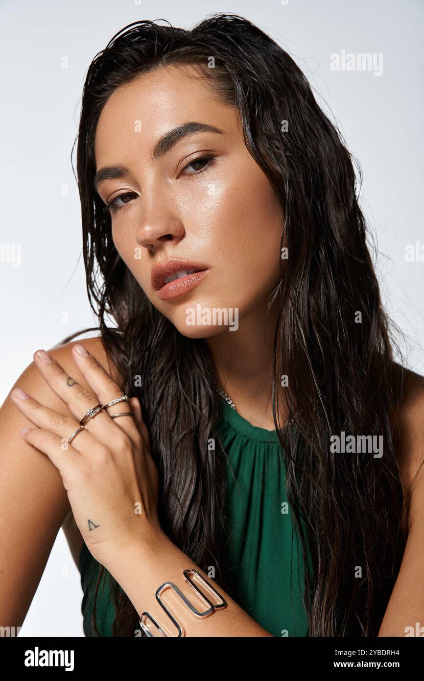 A sophisticated young woman showcases her beauty and elegance with wet ...