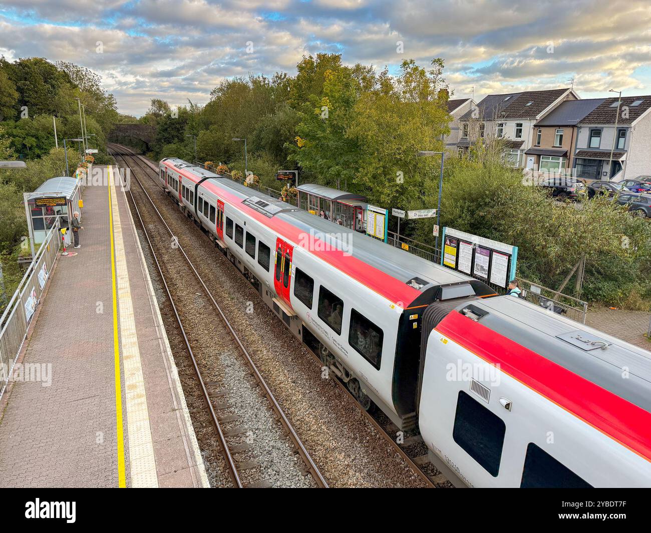 Pontyclun, Wales - 1 October 2024: People getting off and boarding a Transport for Wales Class 197 commuter train stopped at the village station - Smartphone Captured Stock Image