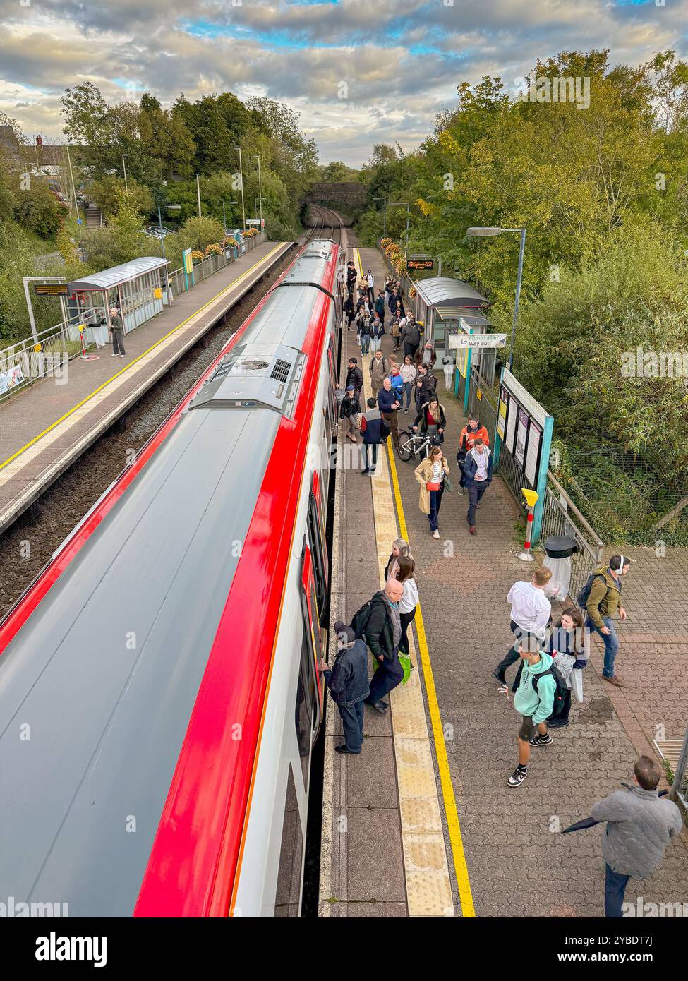 Pontyclun, Wales - 1 October 2024: People getting off and boarding a Transport for Wales Class 197 commuter train stopped at the village station - Smartphone Captured Stock Image