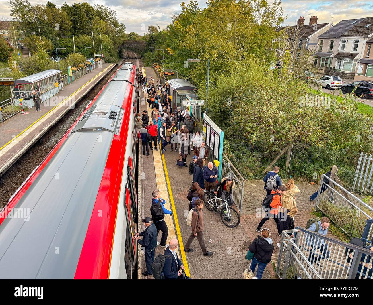 Pontyclun, Wales - 1 October 2024: People getting off and boarding a Transport for Wales Class 197 commuter train stopped at the village station - Smartphone Captured Stock Image