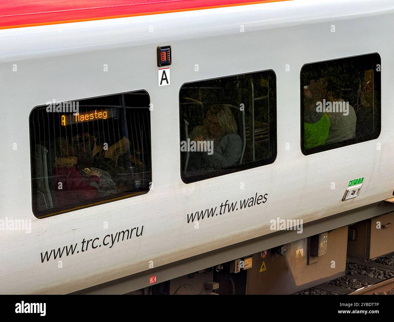 Pontyclun, Wales - 1 October 2024: Close up view of the side of a Transport for Wales Class 197 diesel commuter train stopped at the village station - Smartphone Captured Stock Image