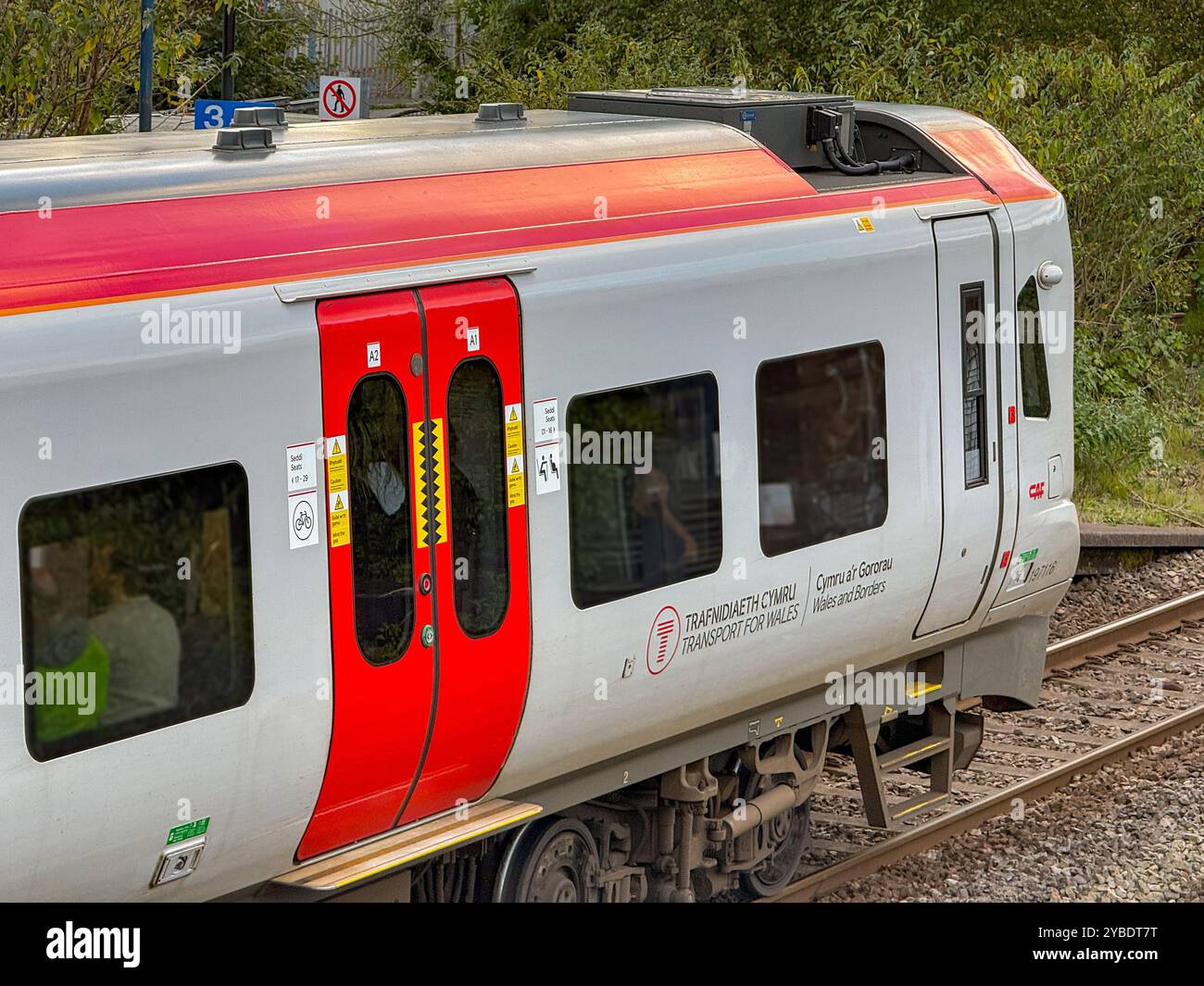 Pontyclun, Wales - 1 October 2024: Close up view of the side of a Transport for Wales Class 197 diesel commuter train stopped at the village station - Smartphone Captured Stock Image