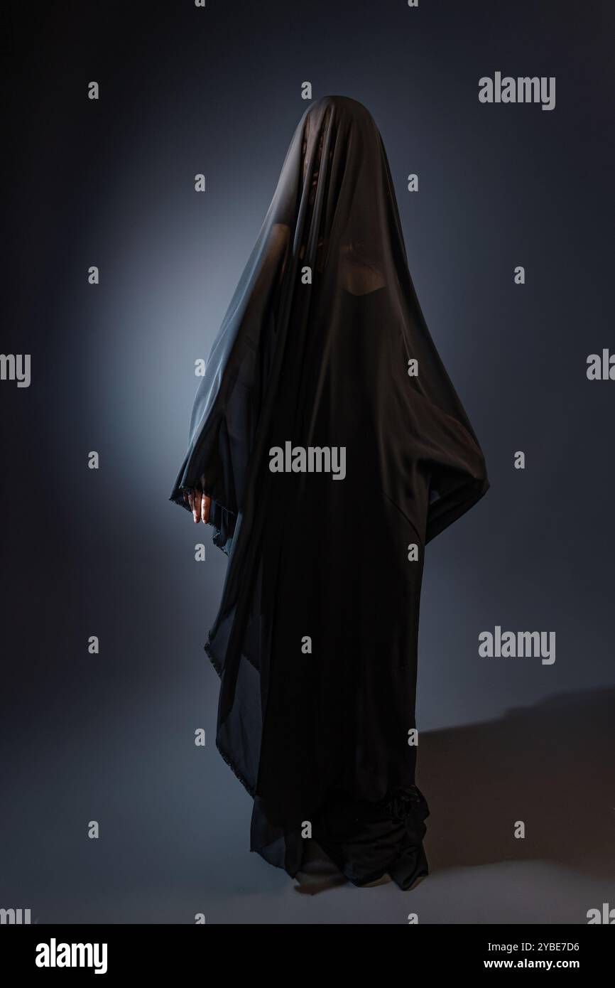 graceful young woman of Caucasian origin, wearing a long, black veil ...