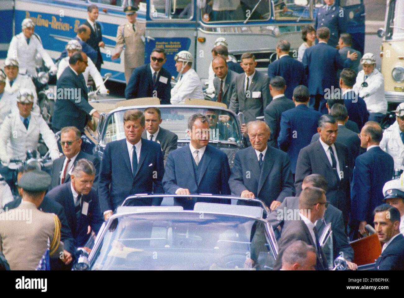 U.S. President John F. Kennedy standing with West Berlin Mayor Willy Brandt and West German Chancellor Konrad Adenauer in open convertible car during his motorcade through West Berlin, West Germany, Cecil Stoughton, White House Photographs, June 26, 1963 Stock Photo