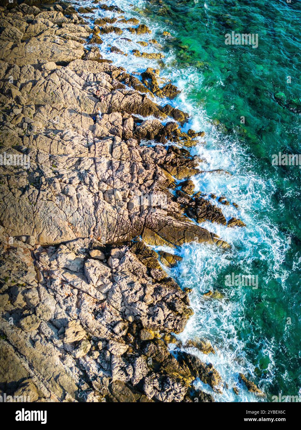Aerial view of waves splashing the Punta Planka shore, with sharp rocks ...