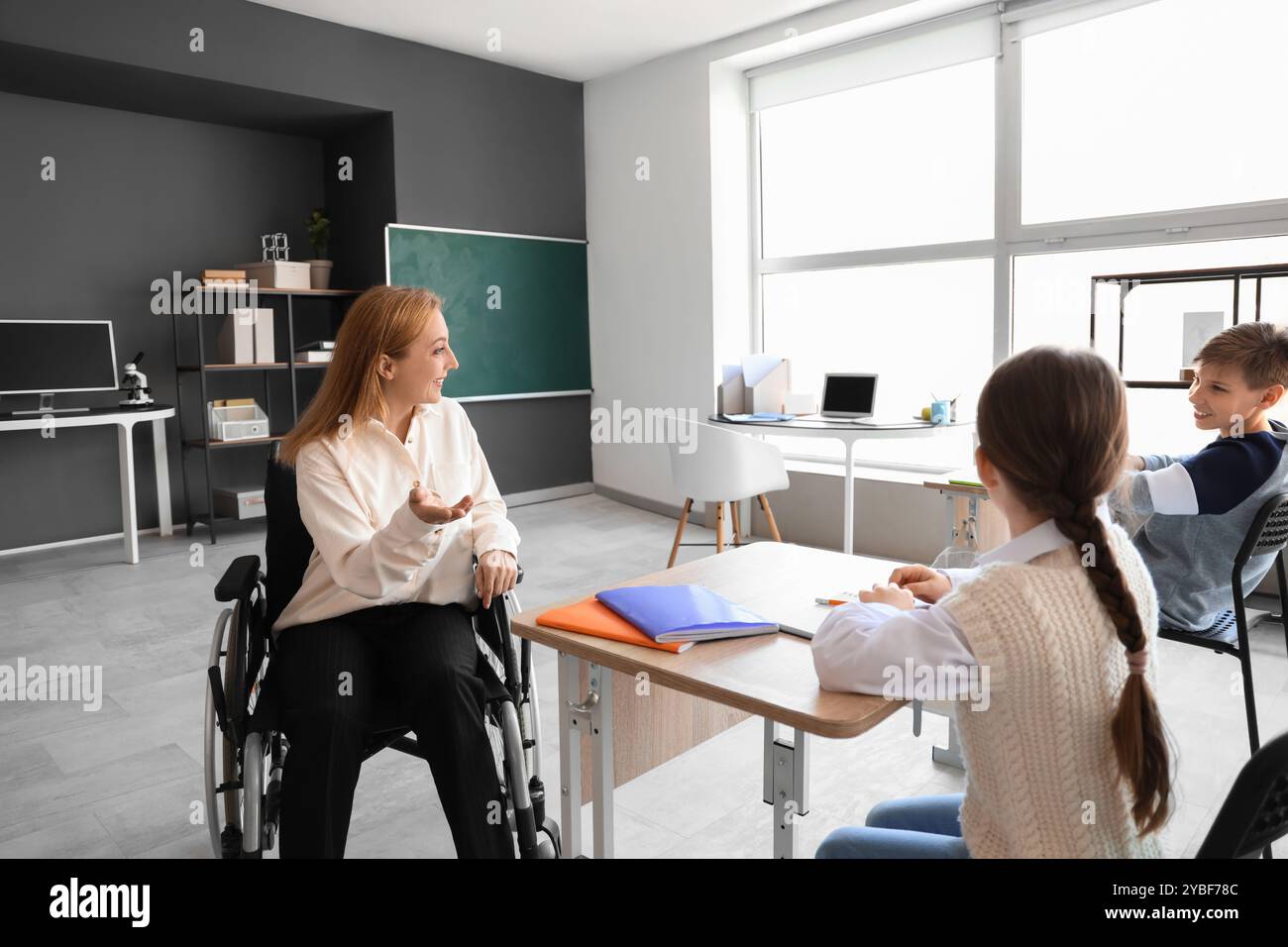 Mature teacher in wheelchair conducting lesson at school Stock Photo ...