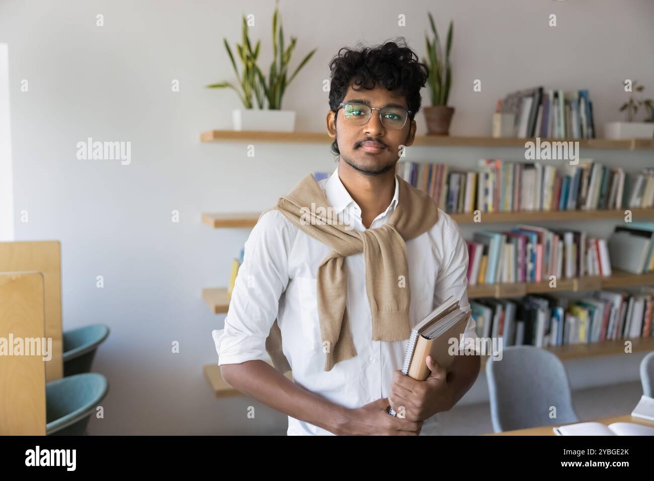 Serious Indian male student in glasses posing for portrait Stock Photo