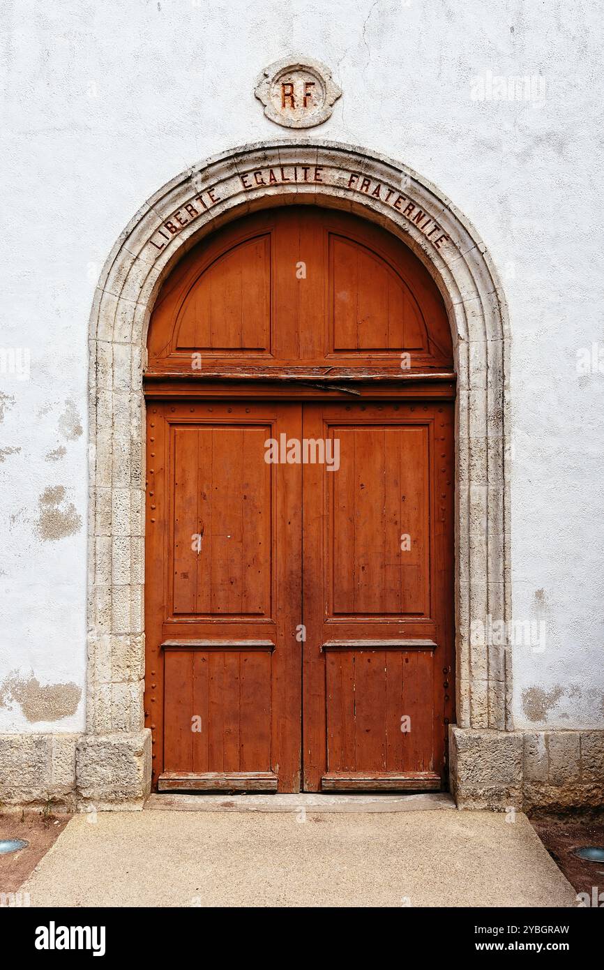 Loix-en-Re, France, August 7, 2018: Beautiful red door in the church of the village. The words Liberte, Egalite, Fraternite, freedom, equality, frater Stock Photo