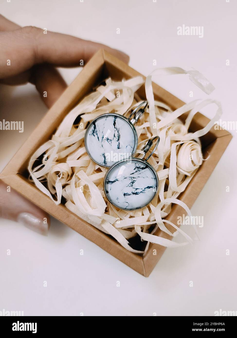 Handmade resin round marble texture stone earrings in small craft paper jewelry box with parcel filler. nature-inspired silver jewelry, accessory - Smartphone Captured Stock Image