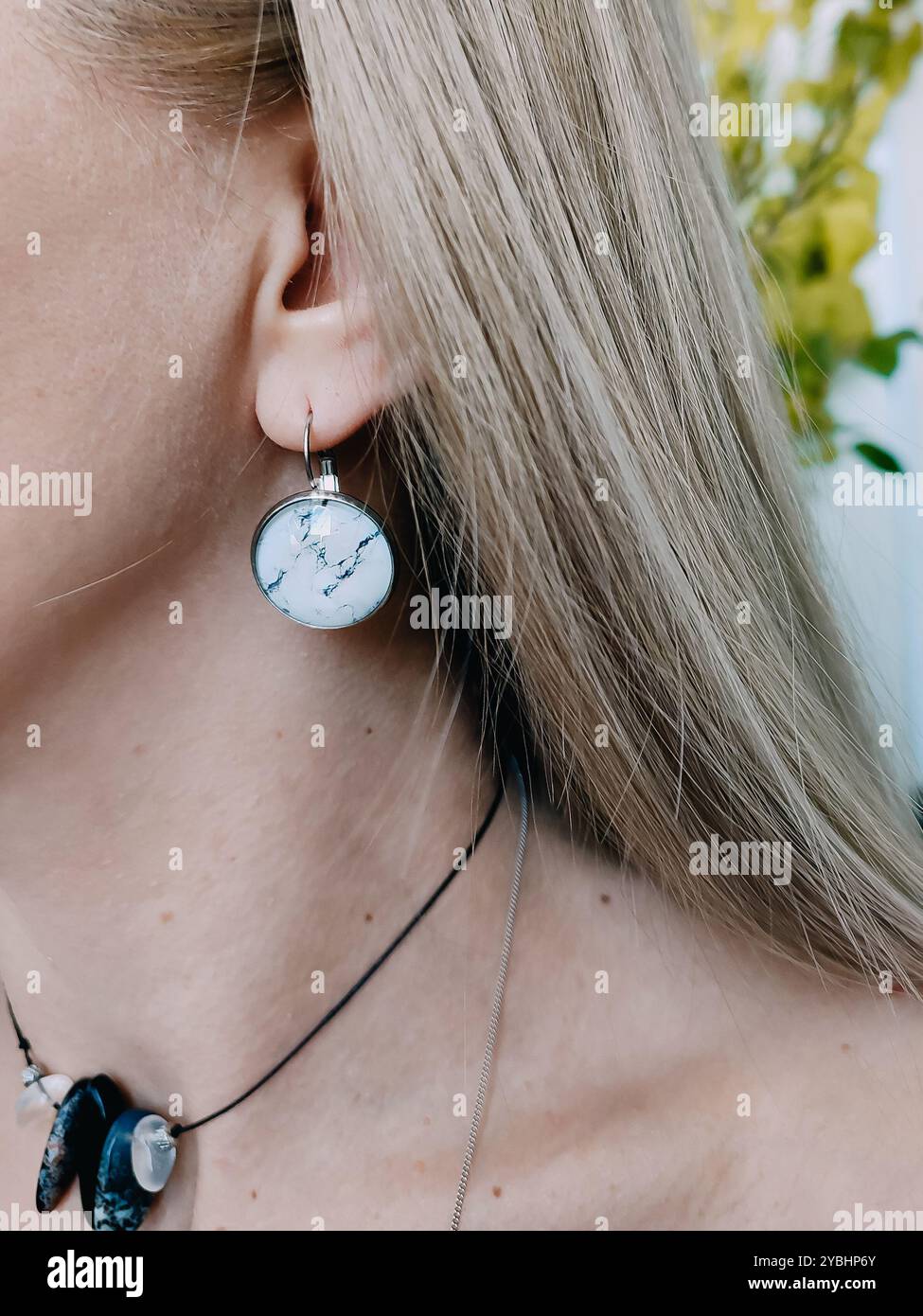 Handmade round white marble resin earrings transparent finish on blonde hair woman's ear. Nature-inspired jewelry collection, jewellery model, stylish - Smartphone Captured Stock Image