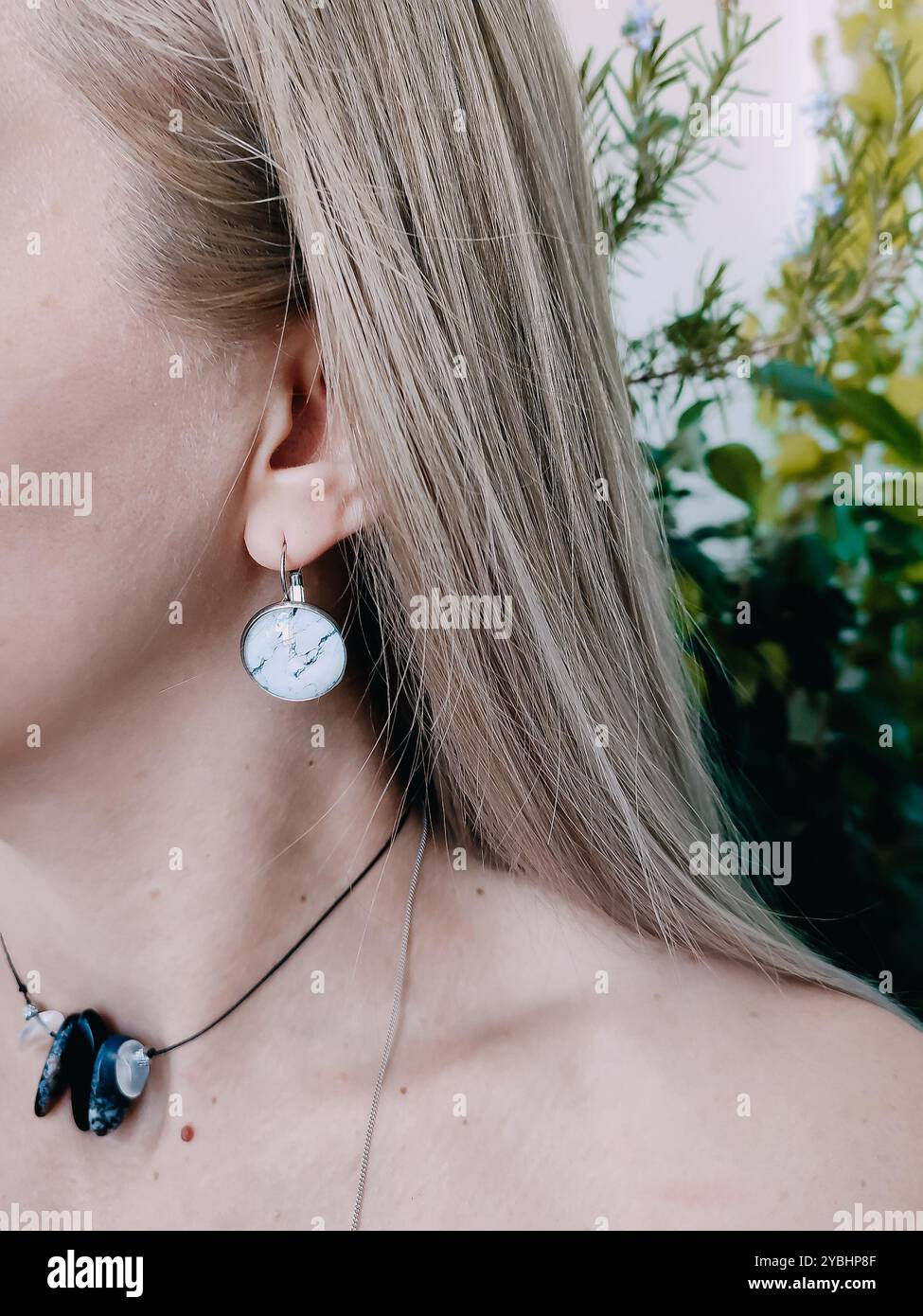 Handmade round white marble resin earrings transparent finish on blonde hair woman's ear. Nature-inspired jewelry collection, jewellery model, stylish - Smartphone Captured Stock Image