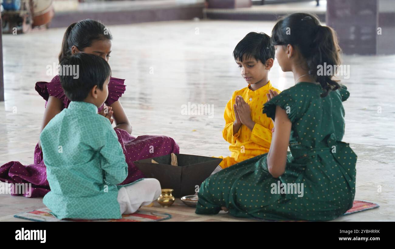 A traditional Indian family engaged in a sacred Yagya ritual to ...