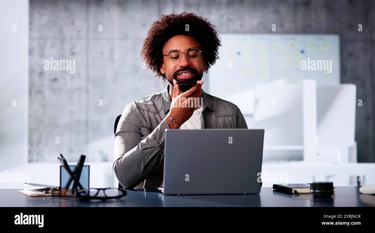 African Man Using Mobile Phone For Voice Messaging Stock Photo