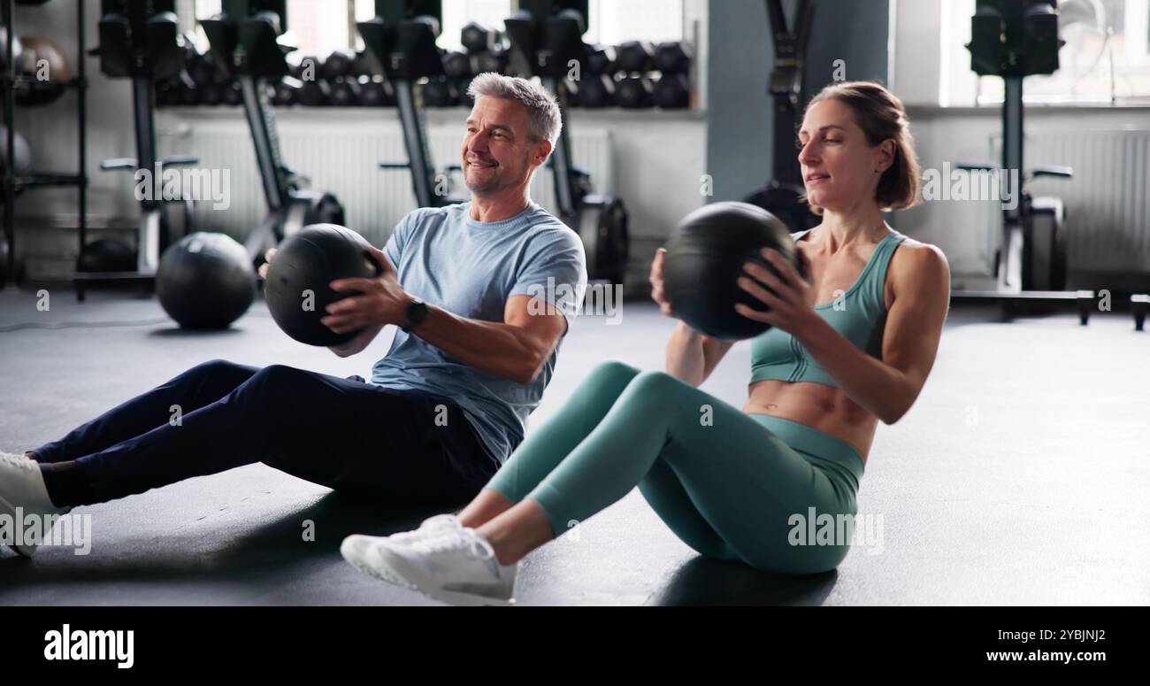 Couple Doing Abdominal Workout In Gym. Fit Athletes Stock Photo