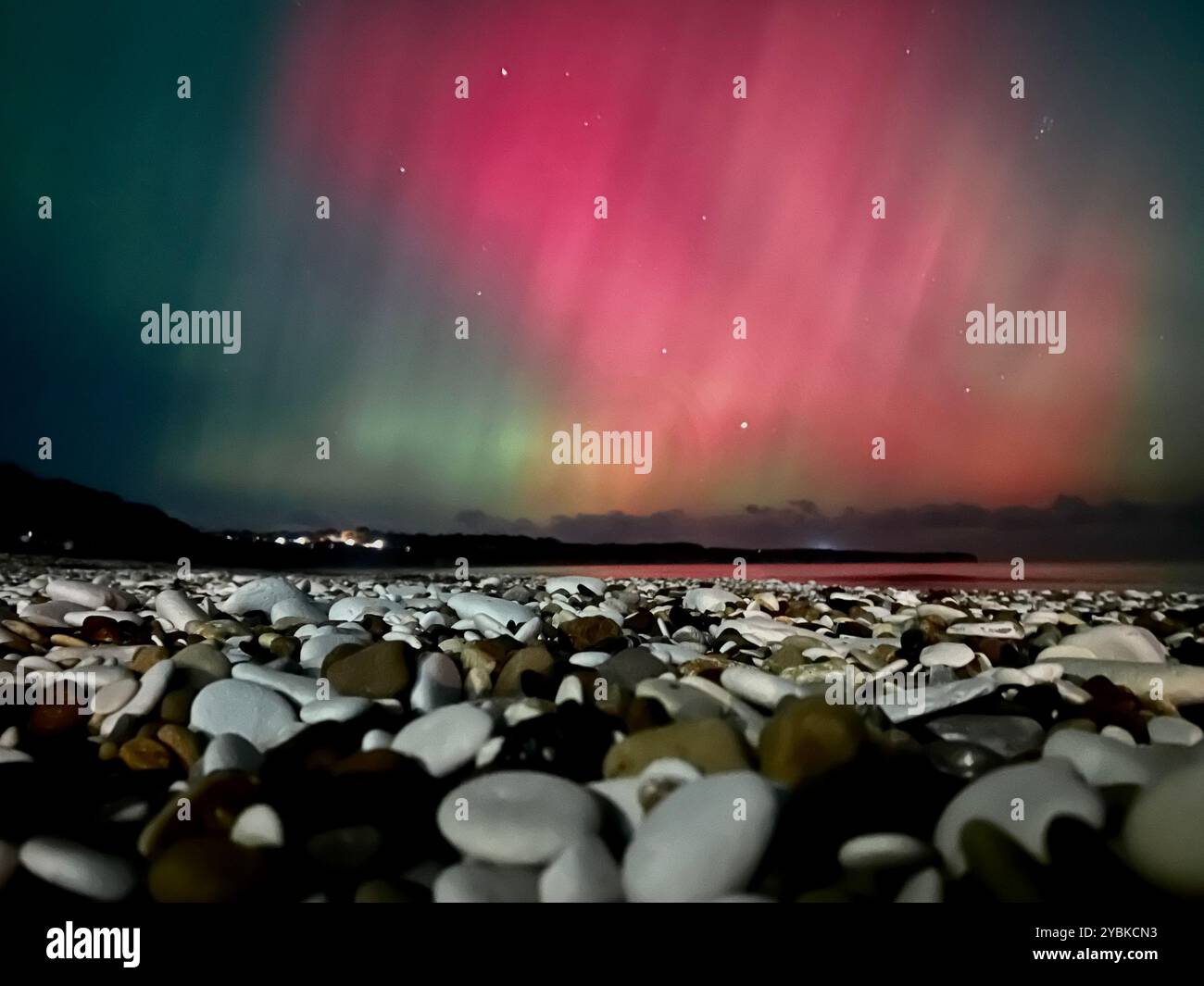 Mesmerizing Northern Lights dance over Bridlington Beach, casting a magical glow on the serene coastline. - Smartphone Captured Stock Image