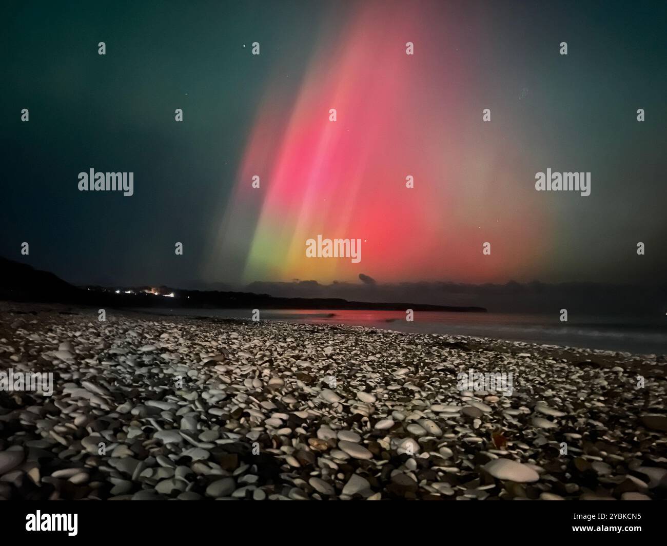 Mesmerizing Northern Lights dance over Bridlington Beach, casting a magical glow on the serene coastline. - Smartphone Captured Stock Image