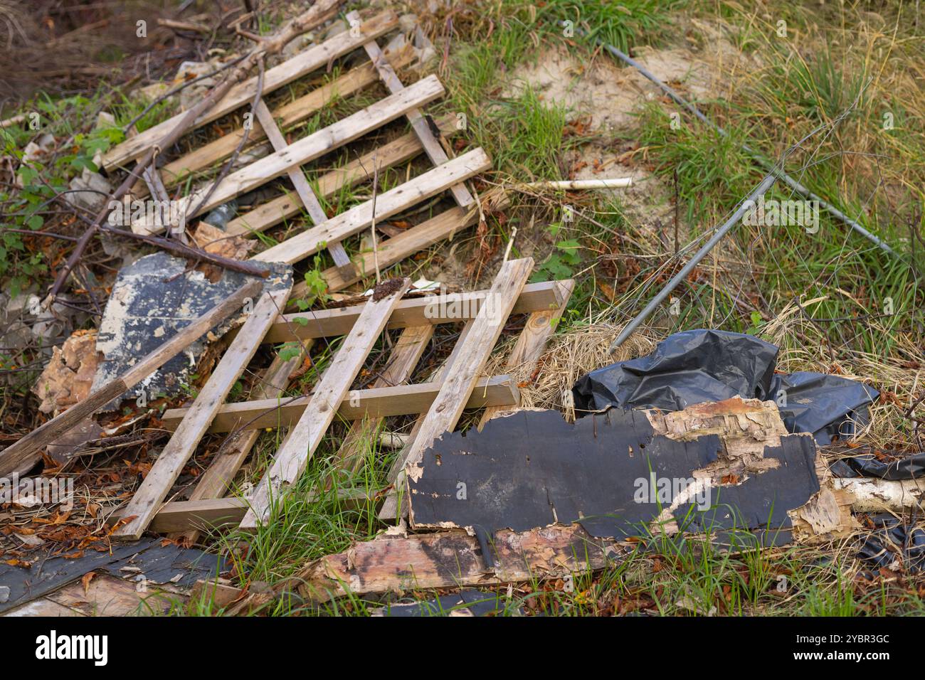 Neglected Materials Broken wooden pallet and debris scattered on the ground in a neglected ...