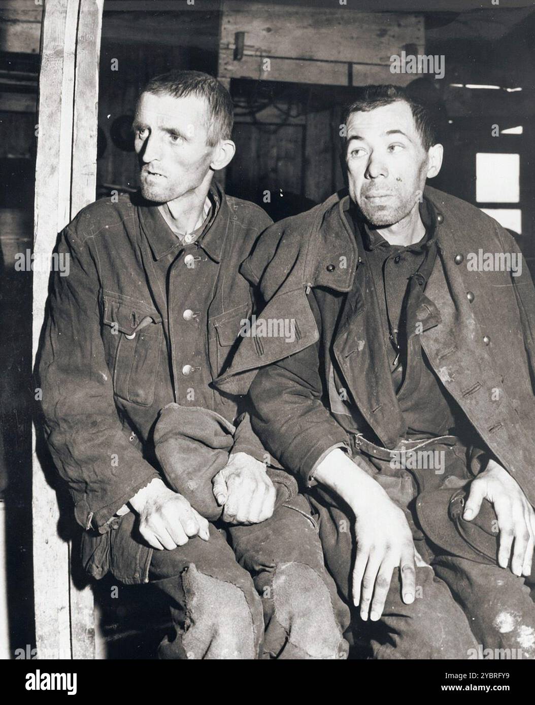 Two former Soviet POWs display the effects of camp imprisonment through their appearence. The man on the left is so thin and weak from starvation that he can hardly stand up by himself. The other's swollen face also indicates suffering from starvation. When the 75th Infantry Division of the U.S. Ninth Army liberated the camp at Hemer, about 22,000 prisoners were liberated. Approximately 9,000 prisoners were hospitalized for tuberculosis, dysentery, malnutrition and typhus fever. Stock Photo