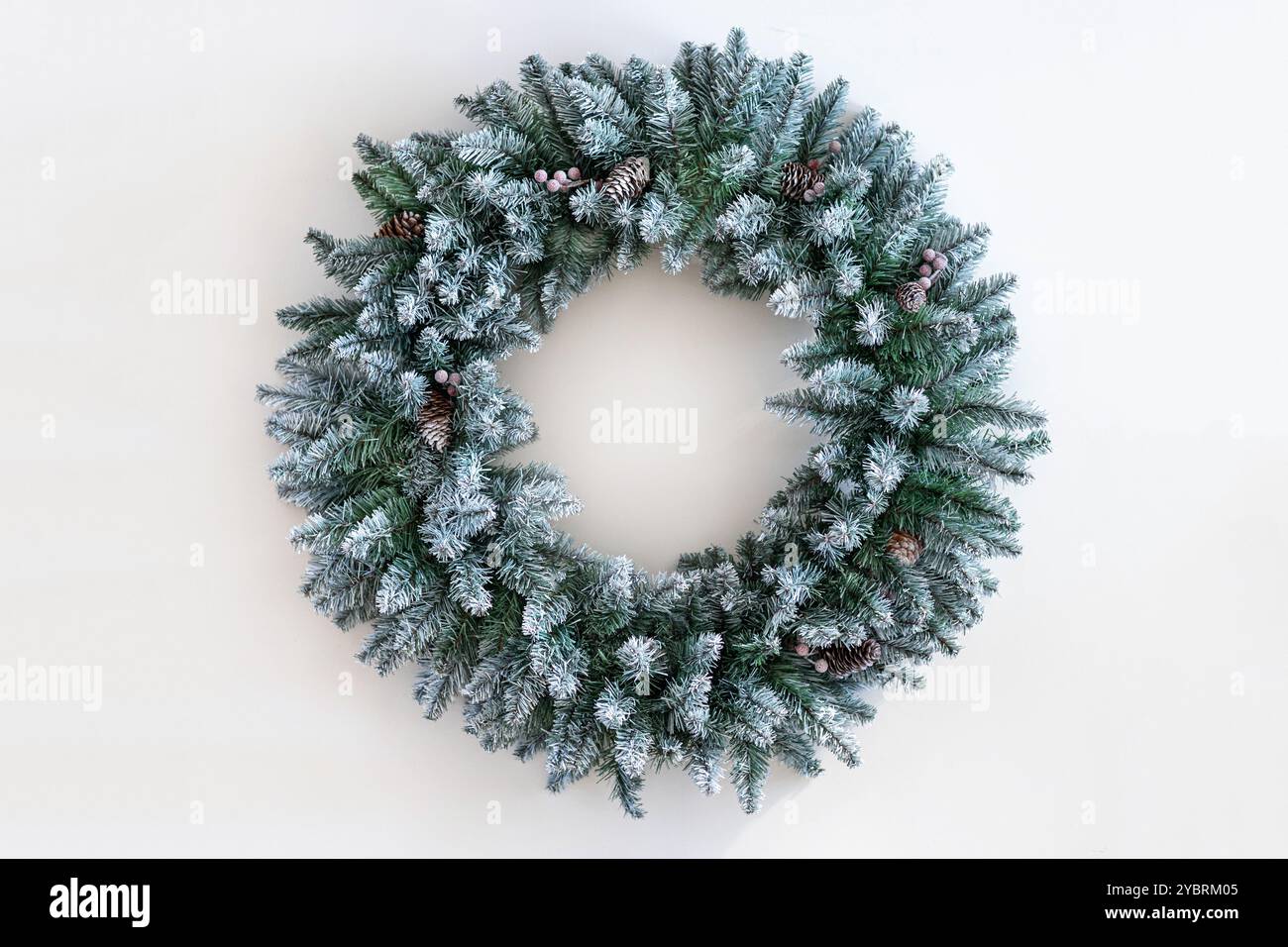 Christmas wreath made of live fir branches and toys on a white ...