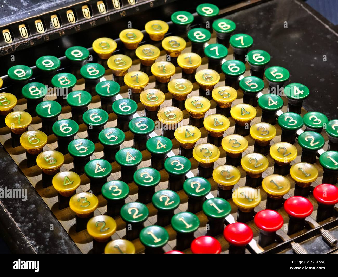 An old fashioned adding machine features a drawer located underneath it Stock Photo