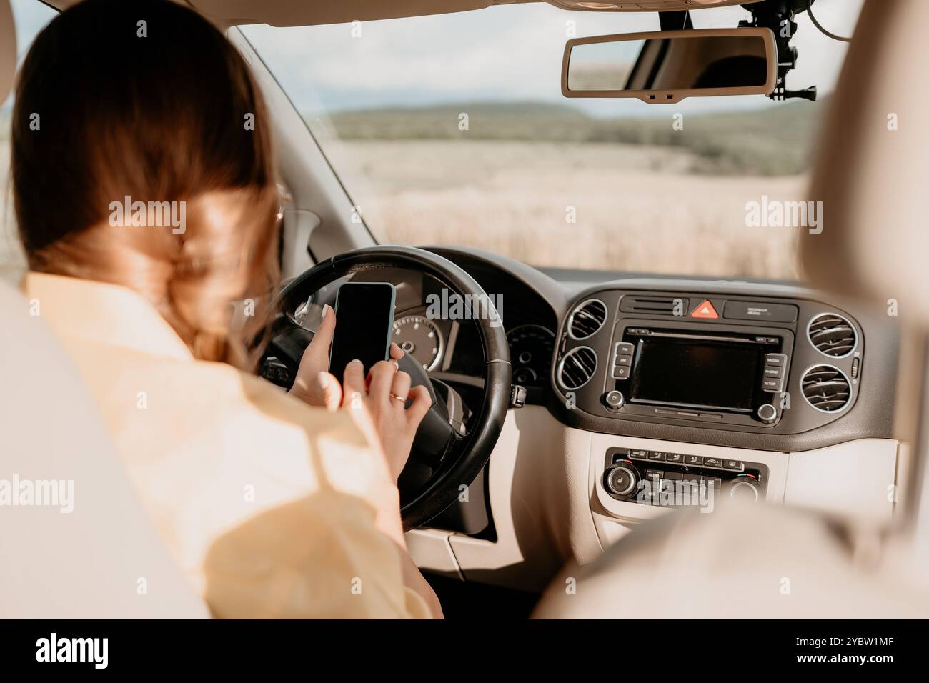 Woman Driving a Car and Texting on Her Phone Stock Photo
