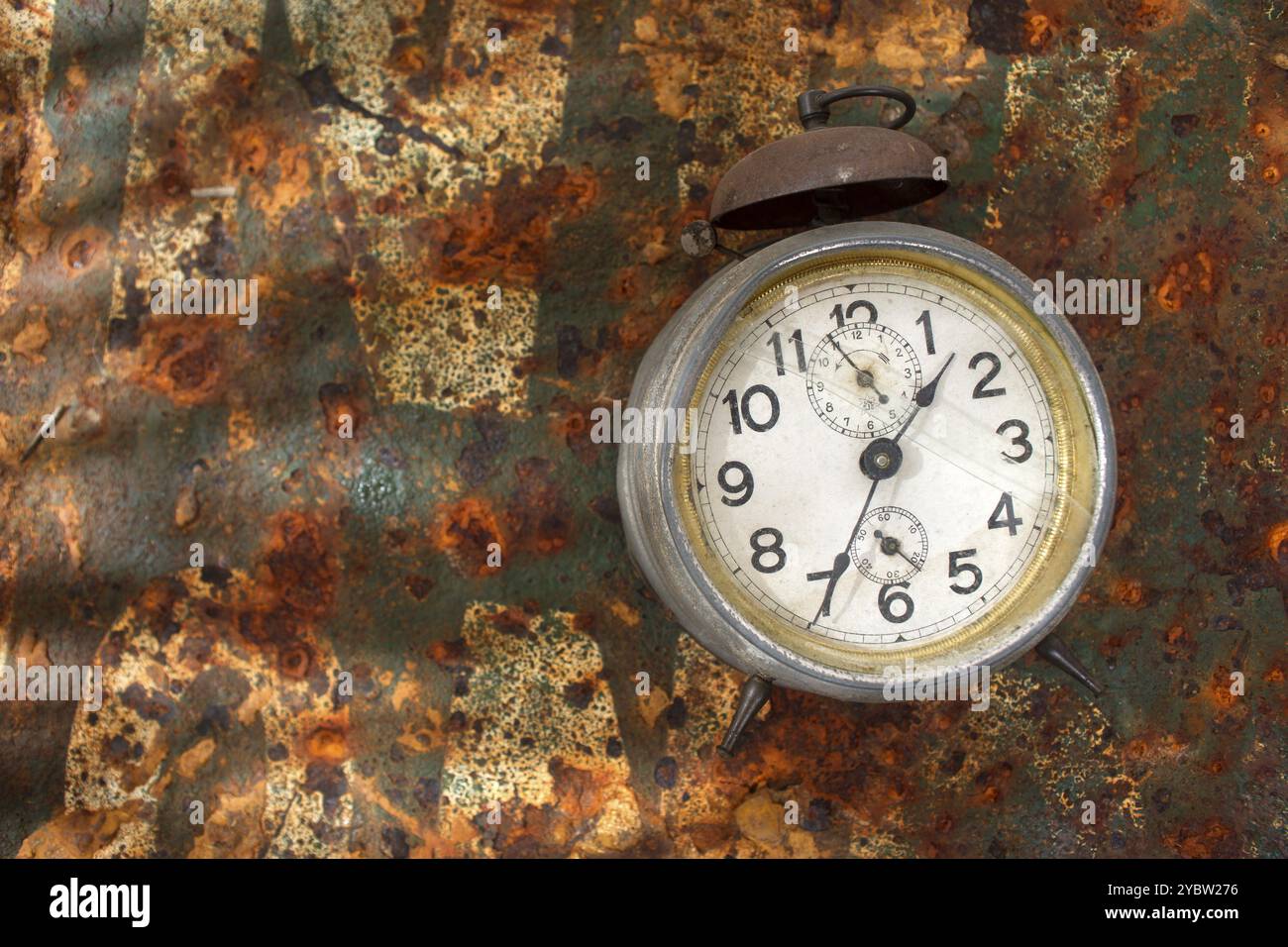 Old alarm clock resting on rusty metallic background Stock Photo - Alamy