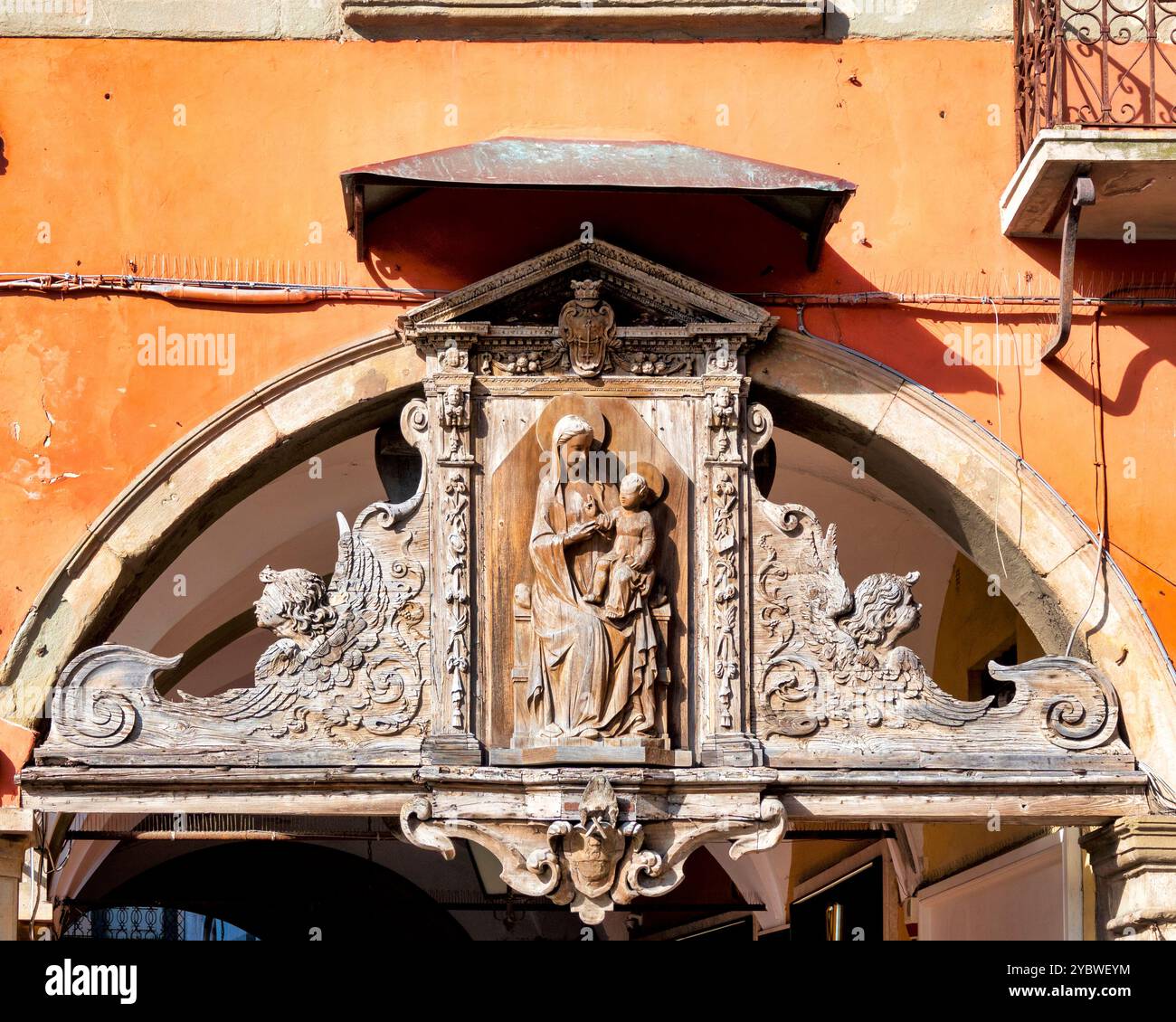 Wooden Madonna and Child sculpture in Borgo Stretto, Pisa, Italy, created by Nino Pisano with a tabernacle by Cosimo d'Arrigo. Stock Photo