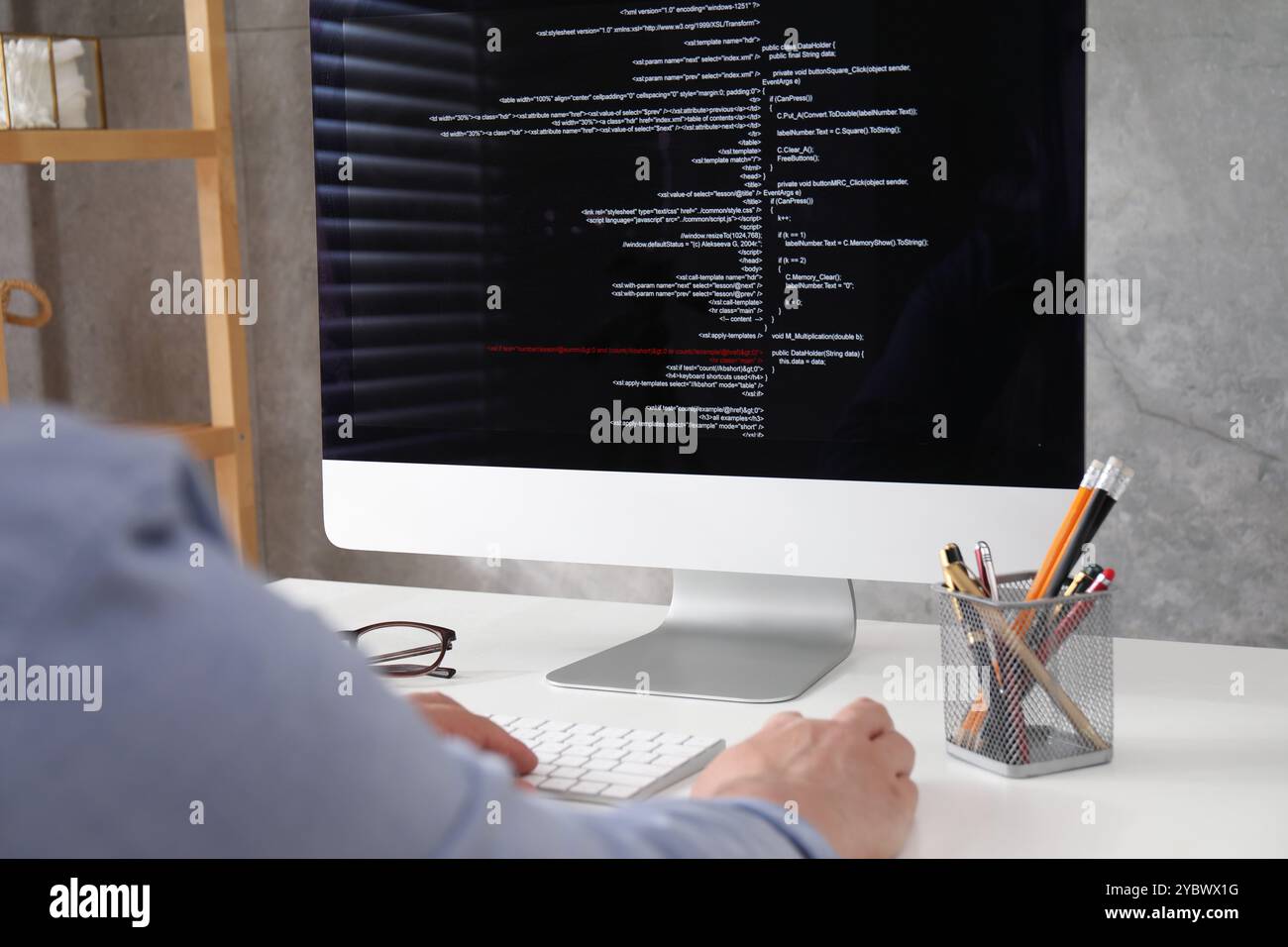 Programmer working with computer at white desk in office, closeup Stock Photo