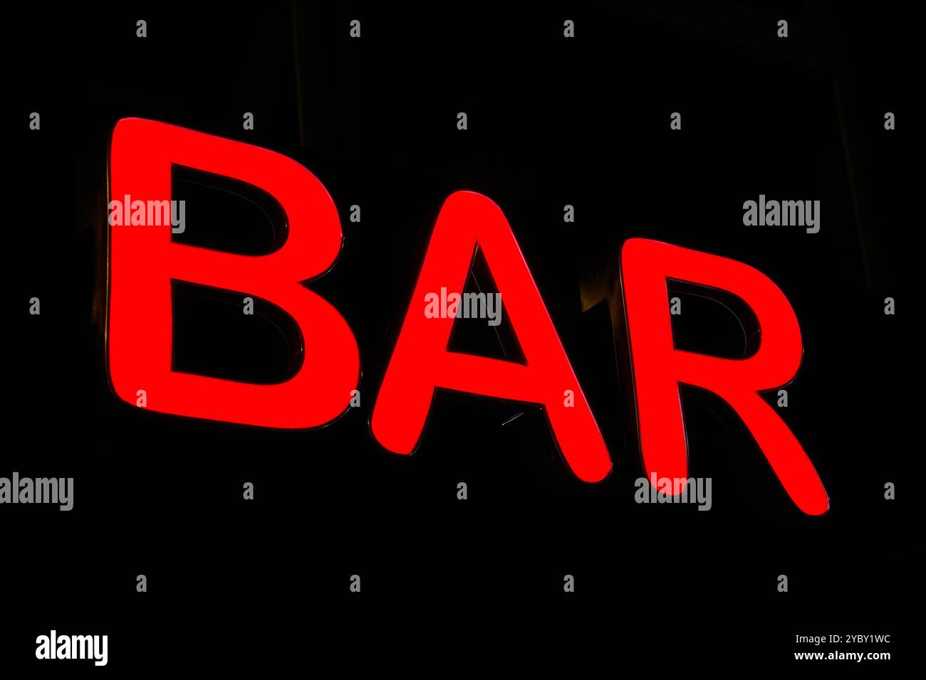 bright red neon sign advertising a bar in a German city center at night Stock Photo