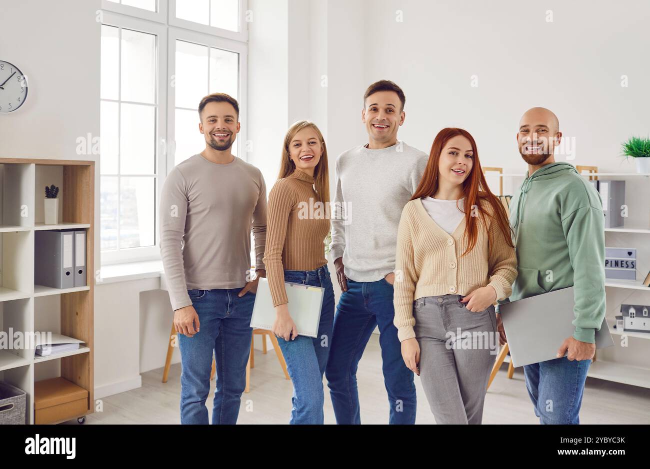 Group of young people looking cheerful at the camera and smiling ...