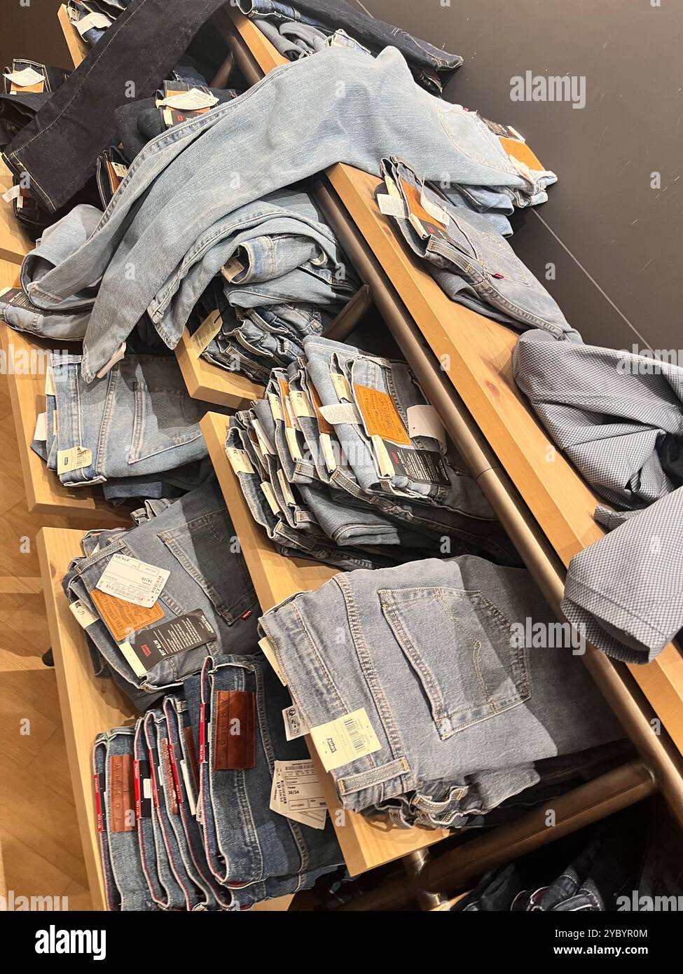 Folded Levi Strauss original jeans various models on shelf in shopping mall - Smartphone Captured Stock Image