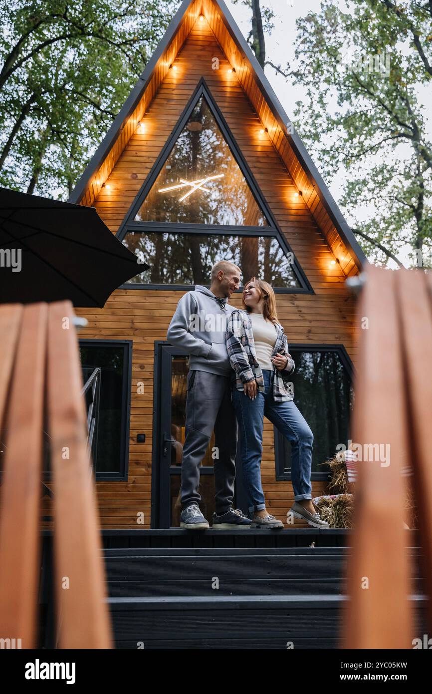 Happy couple enjoying cozy cabin retreat in the forest, creating ...