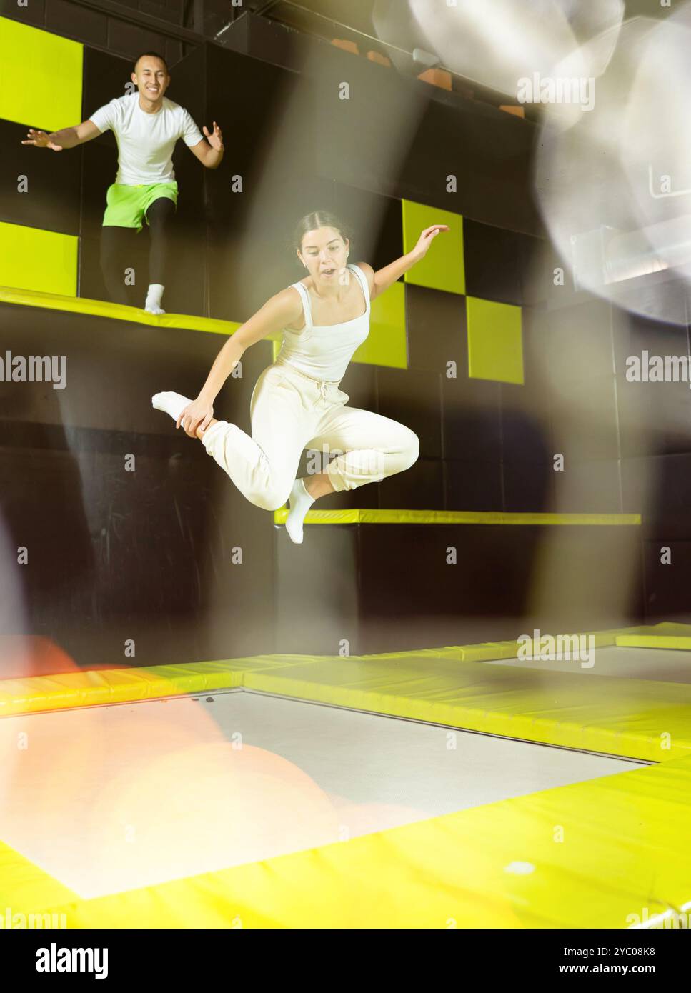 Cheerful young girl jumping in indoor trampoline arena Stock Photo - Alamy