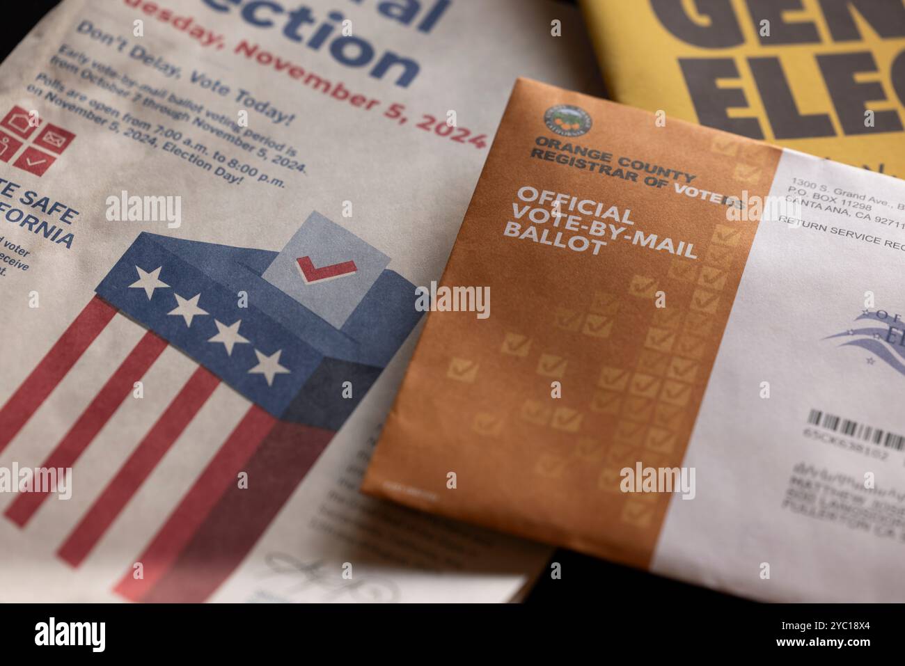 Fullerton, California, USA - October 20, 2024: Afternoon light shines on table of election materials and a vote by mail ballot. Stock Photo