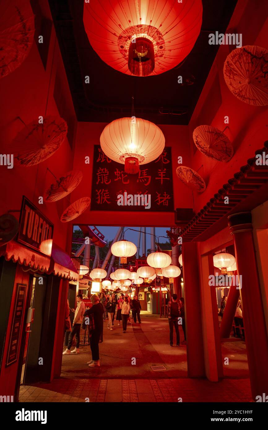 Visitors, Chinese neighbourhood with red lanterns and traditional signs with characters, illuminated at night, Tivoli Amusement and Recreation Park, C Stock Photo