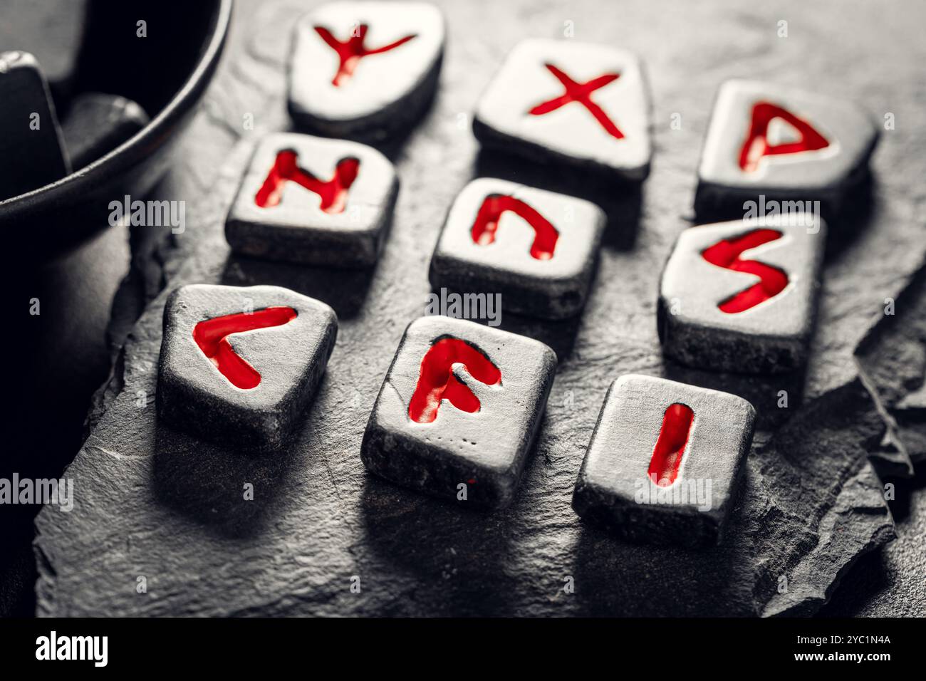 Closeup of enchanted black rune stones with red signs based on futhark ...
