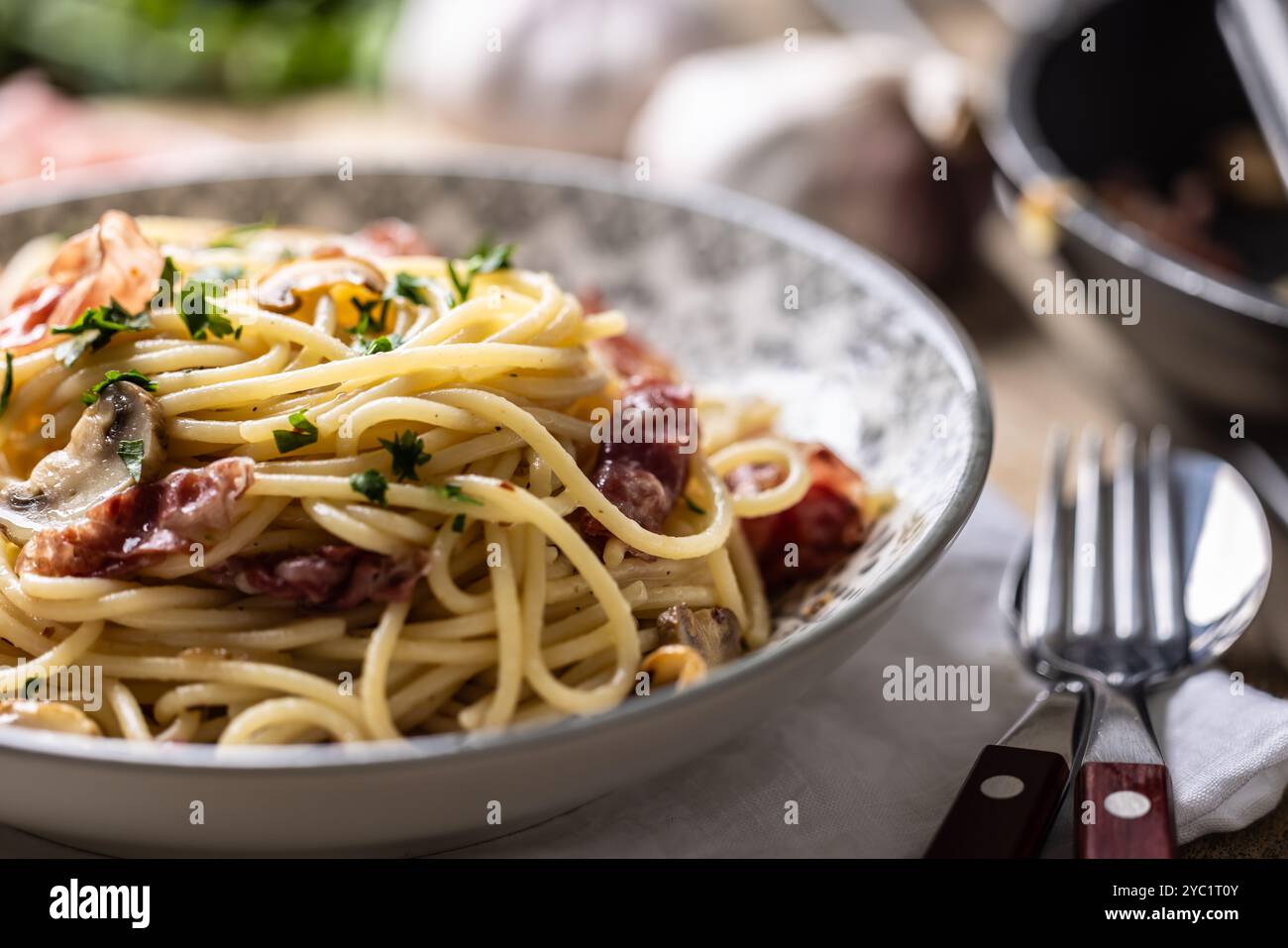 Traditional Italian spaghetti with prosciutto, mushrooms and parmesan. Stock Photo