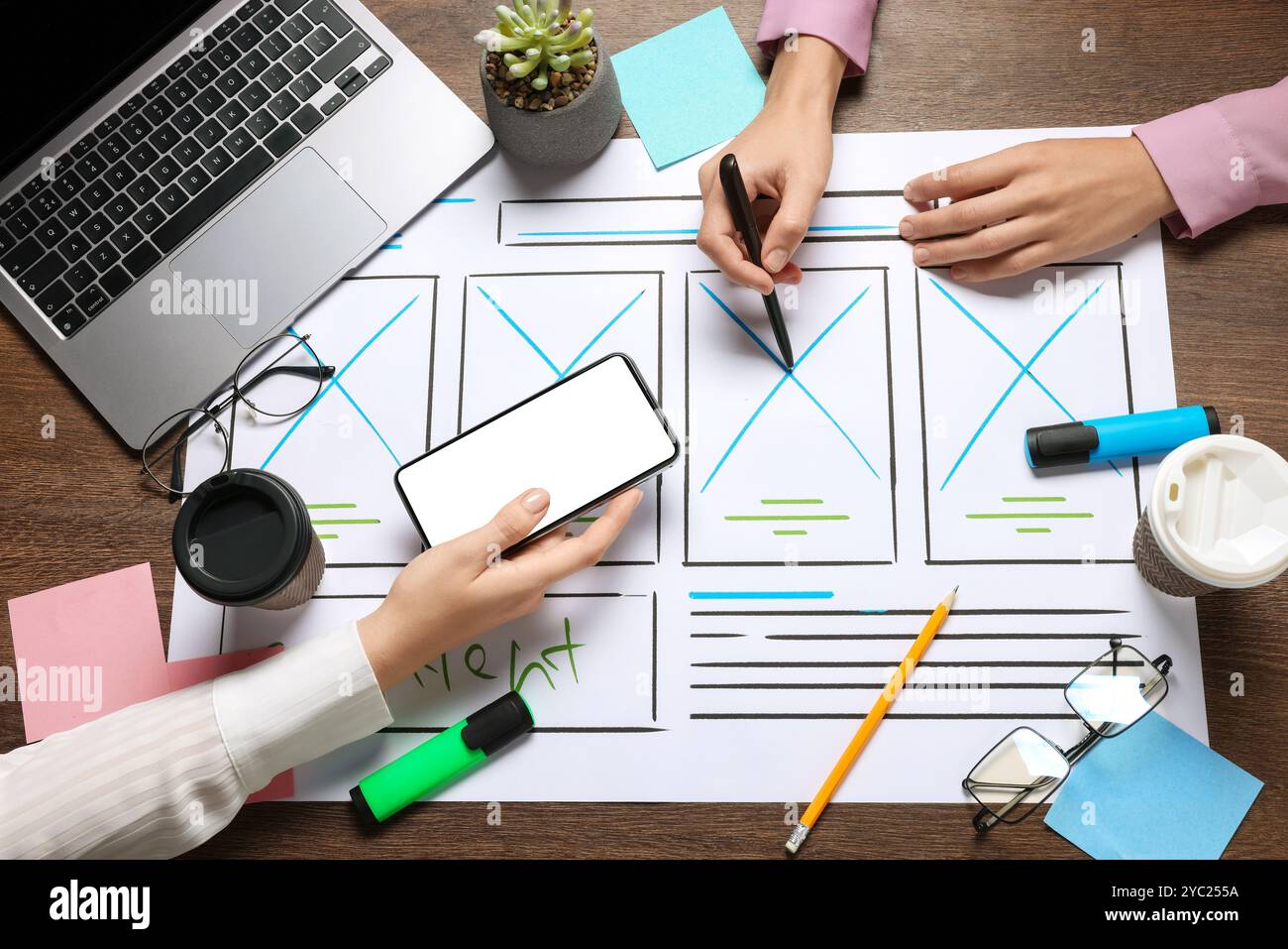 Developing UI design. Designers creating website wireframe on paper at wooden table, top view Stock Photo