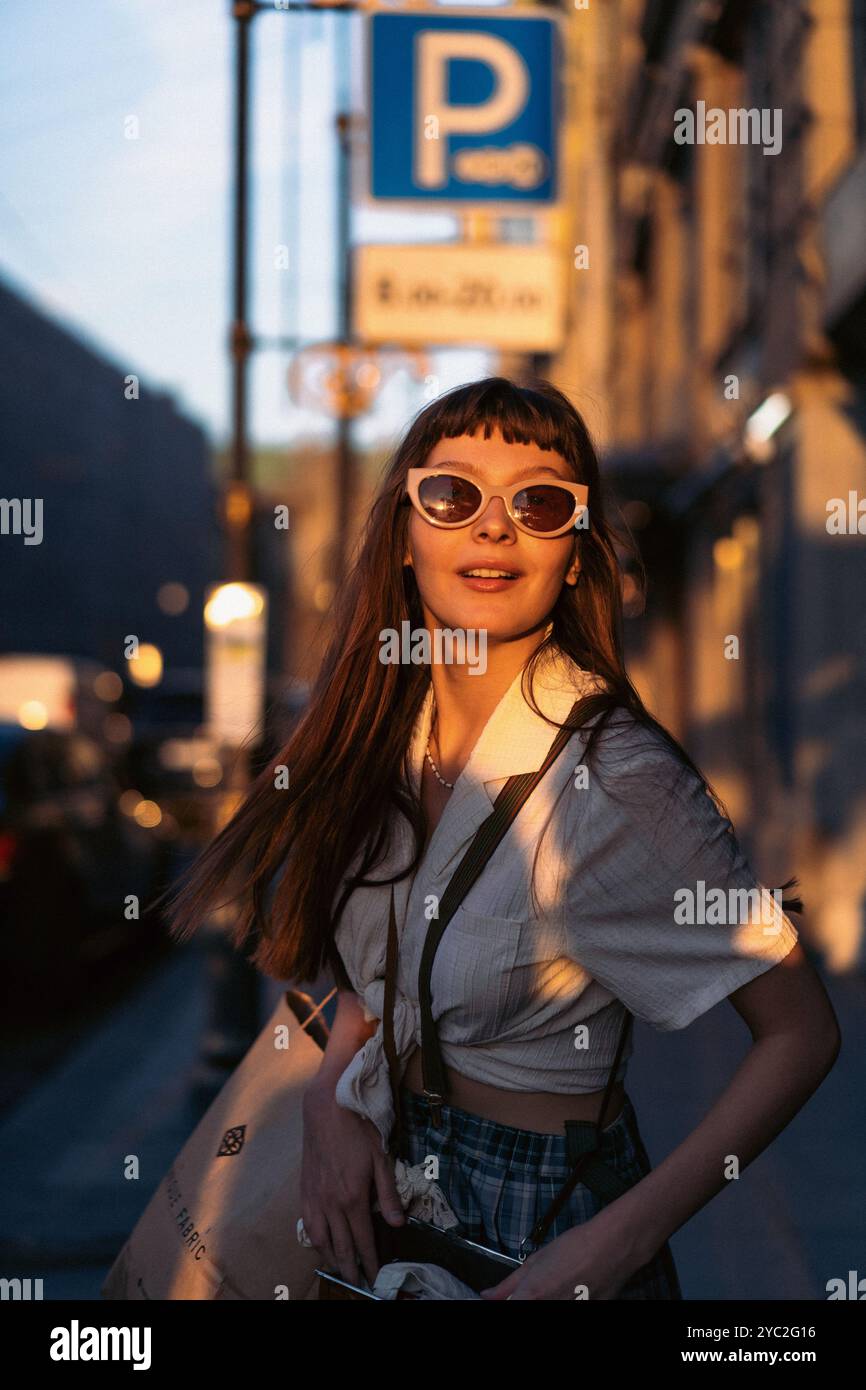 Happy smiling woman standing in city on sunny day. Stock Photo