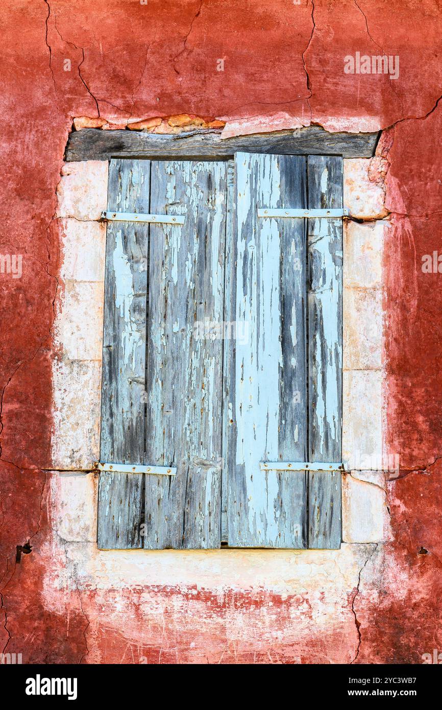 Rustic wooden shutters and red wall Stock Photo