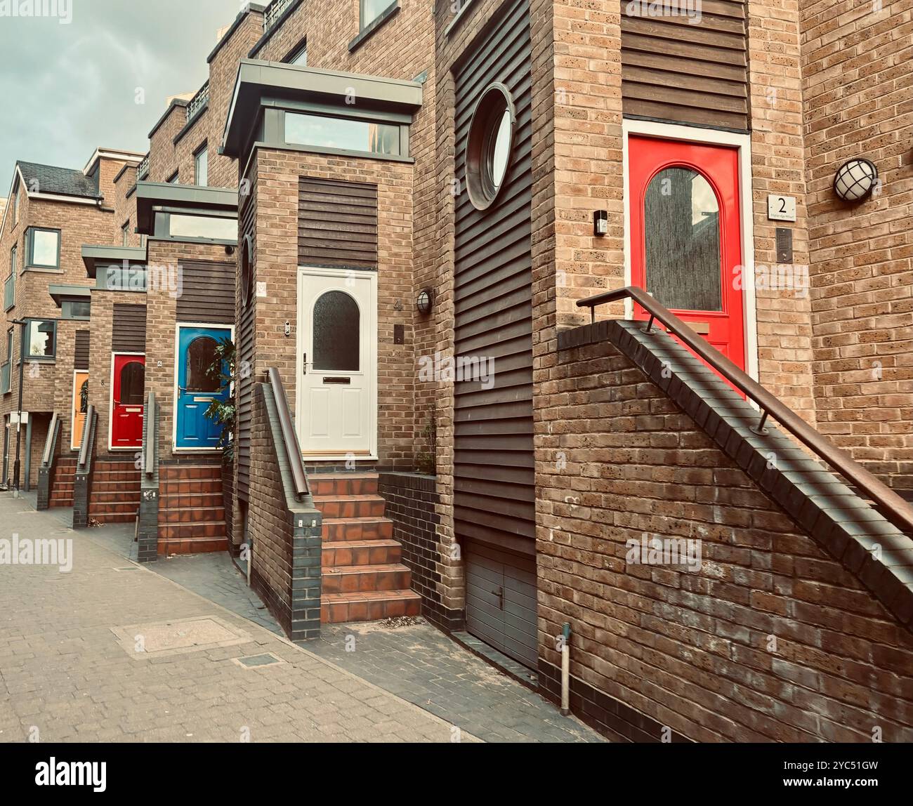 Modern urban row houses with vibrant doors and brick architecture, showcasing a blend of contemporary design and traditional charm - Smartphone Captured Stock Image