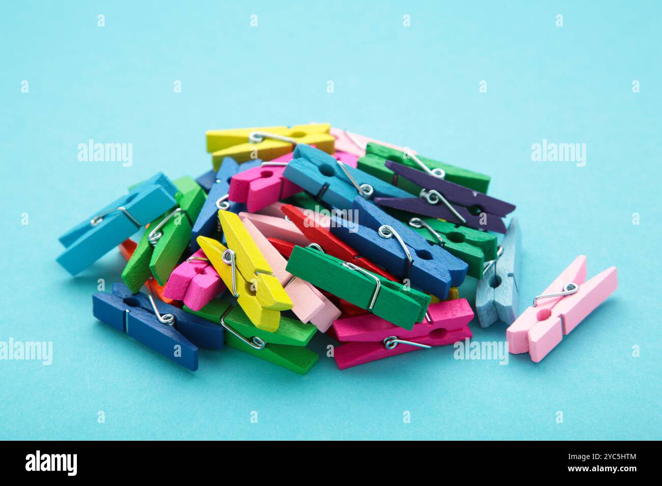 Colored wooden clothespins on blue background. Design elements. Macro. Space for text Stock Photo
