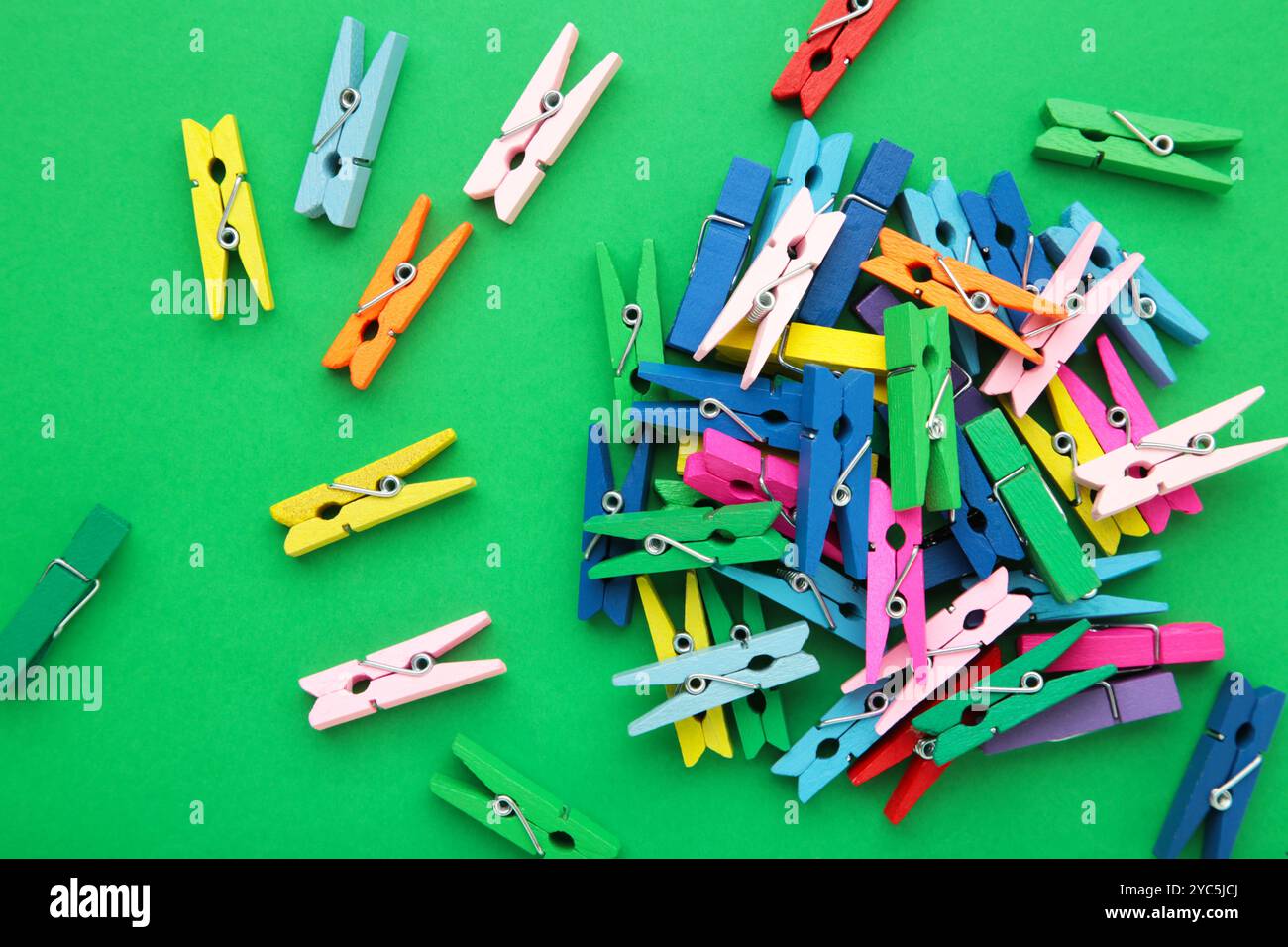 Colored wooden clothespins on green background. Design elements. Macro. Space for text Stock Photo