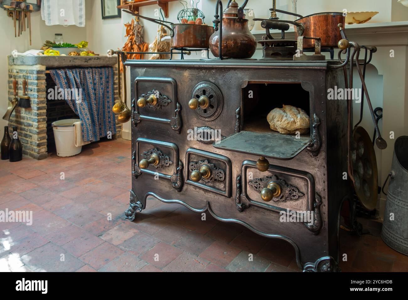 Antique cast-iron stove in kitchen inside 18th century clergy house Schriek at recreated village in open air museum Bokrijk, Limburg, Belgium Stock Photo