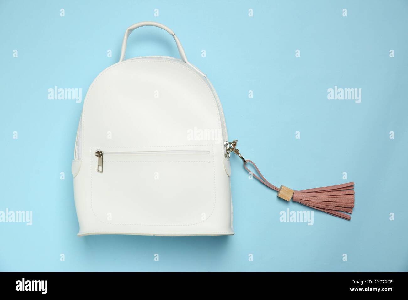 Backpack with pink leather keychain on light blue background, top view Stock Photo